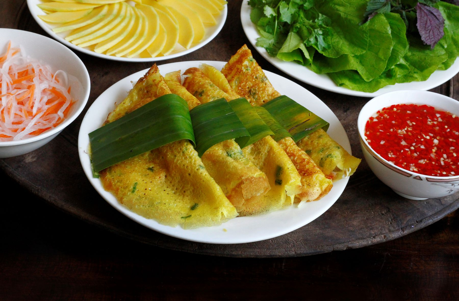 Crispy Vietnamese Banh Xeo crepe filled with fresh prawns and bean sprouts served with salad greens