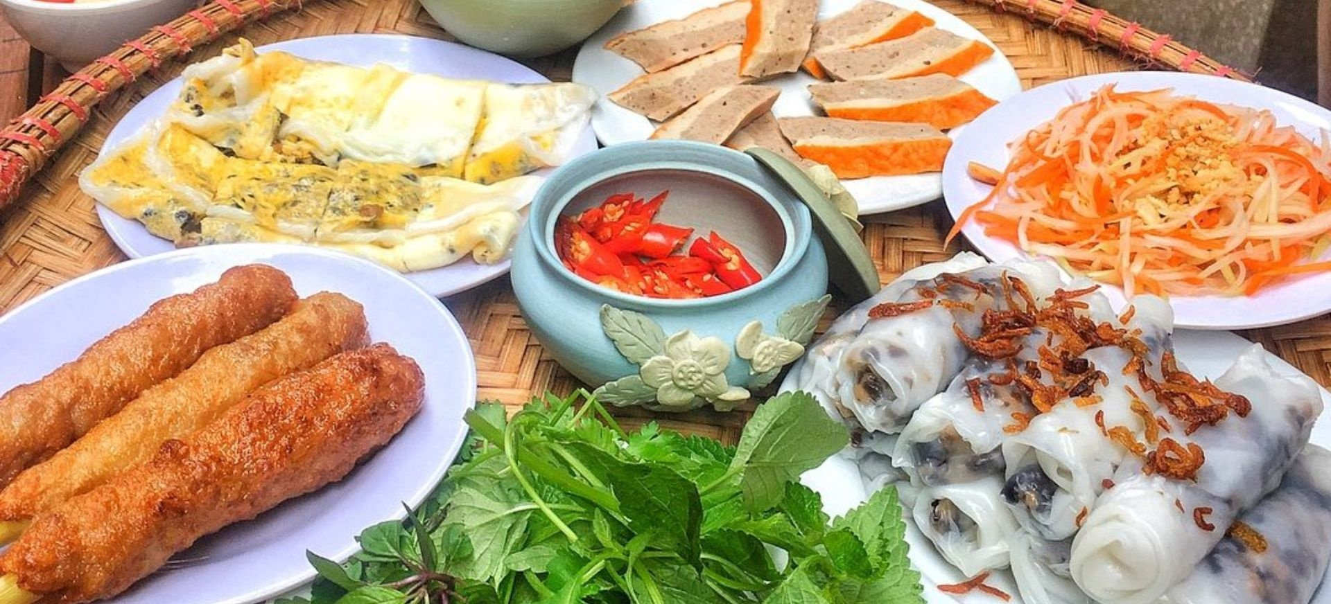 Delicate Vietnamese Banh Cuon steamed rice rolls served with nem chua and fresh herbs