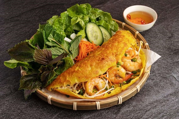 Crispy Vietnamese Banh Xeo crepe filled with fresh prawns and bean sprouts served with salad greens