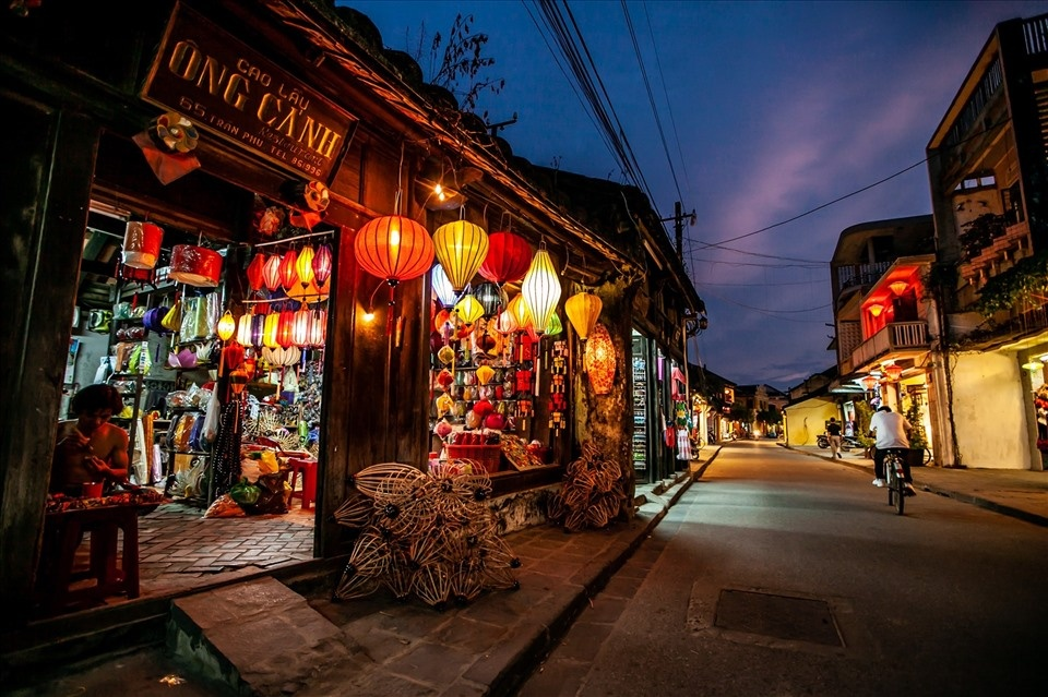 Illuminated traditional silk lantern shop and historic wooden storefront in Hoi An Ancient Town at dusk