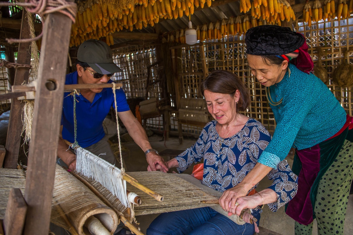 Tourist learning traditional linen weaving in Lung Tam village
