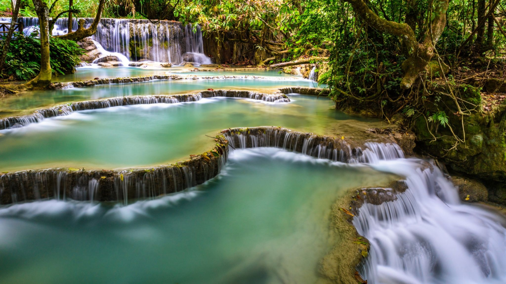 Multi-tiered Kuang Si waterfall flowing into turquoise pools in Luang Prabang