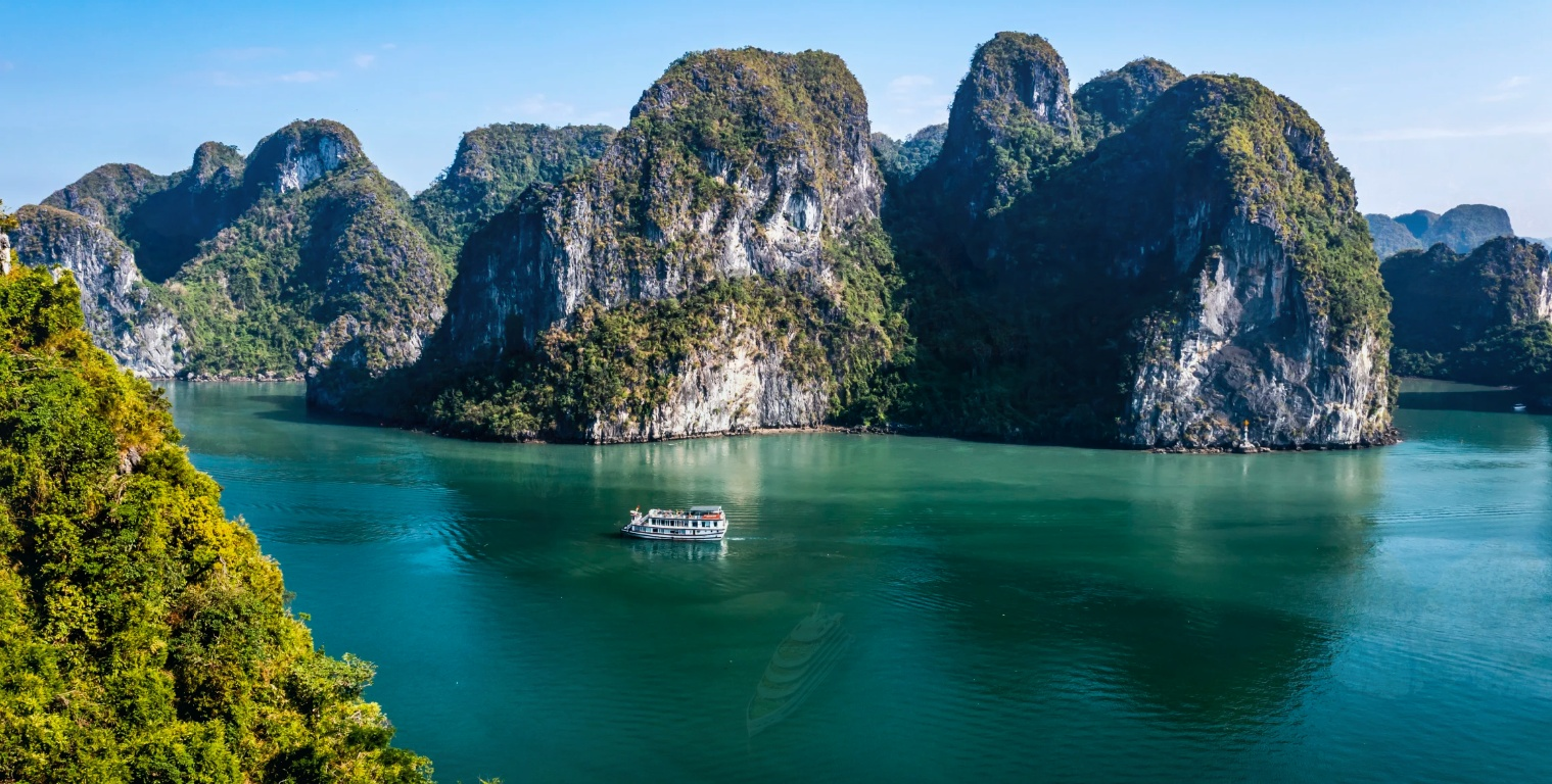 Luxury cruise sailing through limestone karst islands in Ha Long Bay