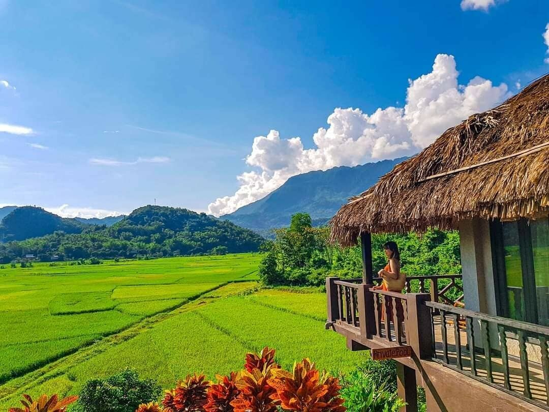 Eco-luxury resort with stilt bungalows against misty mountains in Mai Chau